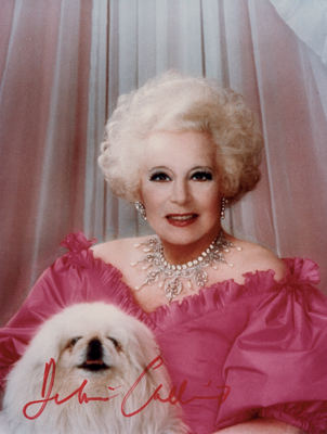 Une photo de Barbara Cartland en rose et avec son petit chien